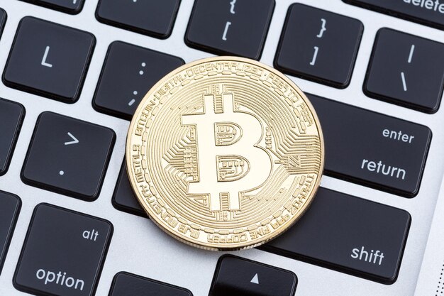 Pièce de monnaie bitcoin en or physique de crypto-monnaie sur le clavier photo haute résolution