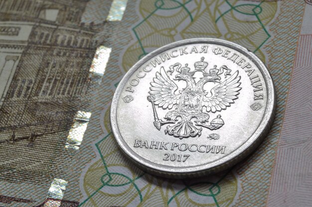 Pièce de monnaie russe d'une valeur nominale de 1 rouble se trouve sur un billet Traduction des inscriptions sur la pièce "Banque de la Fédération de Russie de Russie"