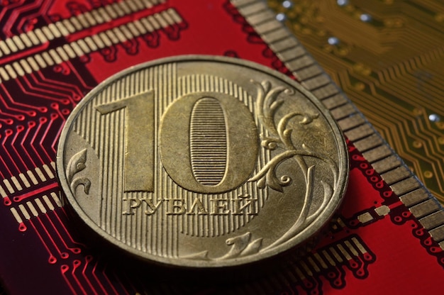 Une pièce de monnaie russe d'une valeur nominale de 10 roubles se trouve parmi les microcircuits un concept illustrant la tarification de l'électronique en Russie