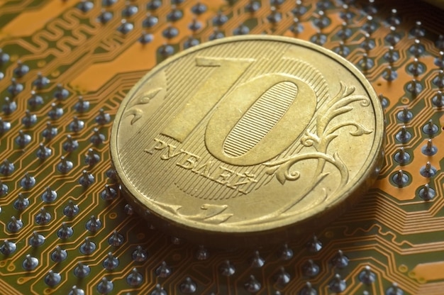 Une pièce de monnaie russe d'une valeur nominale de 10 roubles se trouve à la surface du microcircuit un concept illustrant la tarification de l'électronique en Russie