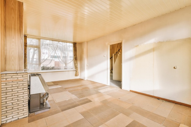 Une pièce vide spacieuse avec une petite cheminée et une fenêtre lumineuse