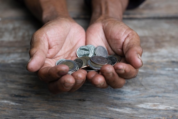 Pièces d'argent Pension de grand-père et concept de vie minimal Le vieux grand-père recueille malheureusement une petite pièce sur une table en bois