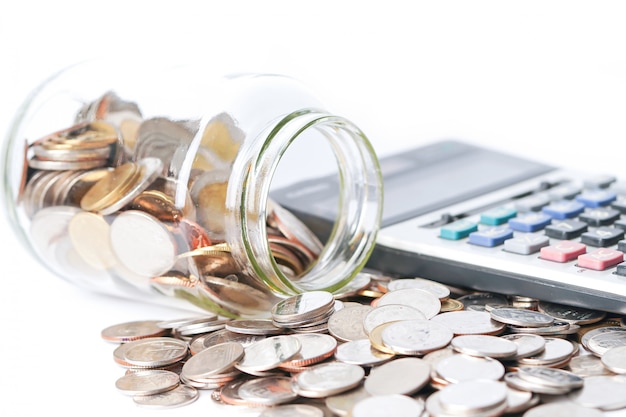 Pièces en bouteille en verre avec calculatrice sur fond blanc