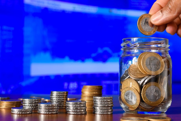 Des pièces dans un pot de verre sur le fond de la bourse