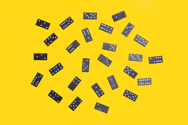 Pièces de domino noir sur fond jaune en vue de dessus