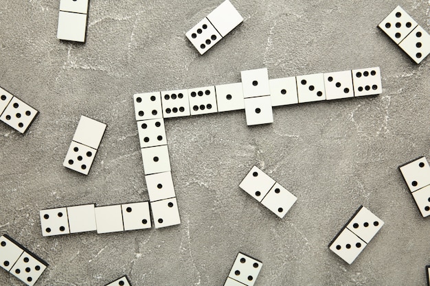 Pièces de domino sur la surface grise