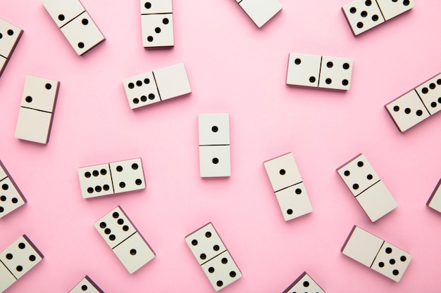 Pièces de domino sur la surface rose