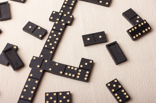 Pièces de dominos en noir sur une table lumineuse