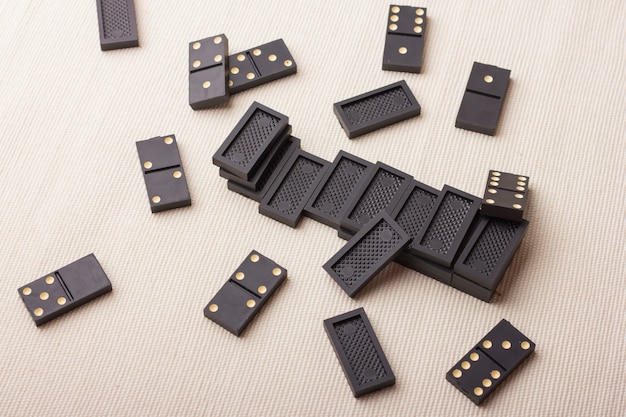 Pièces de dominos en noir sur une table lumineuse