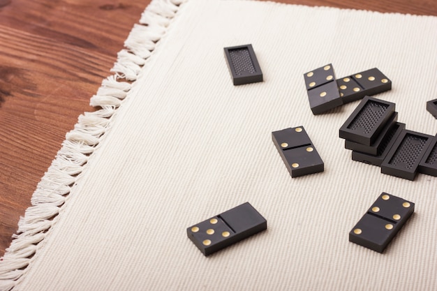 Pièces de dominos en noir sur une table lumineuse