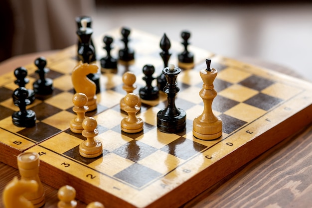 Pièces d'échecs en bois sur un jeu de société, sur table vintage, mise au point sélective.