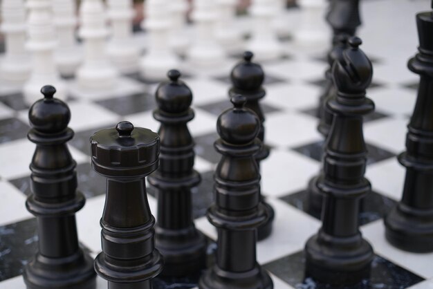 Pièces d'échecs en noir et blanc debout sur des planches en gros plan sur la rue