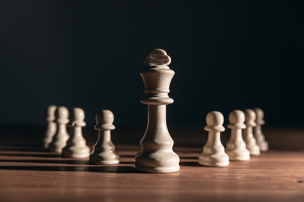 Pièces d'échecs sur la table sur un mur sombre