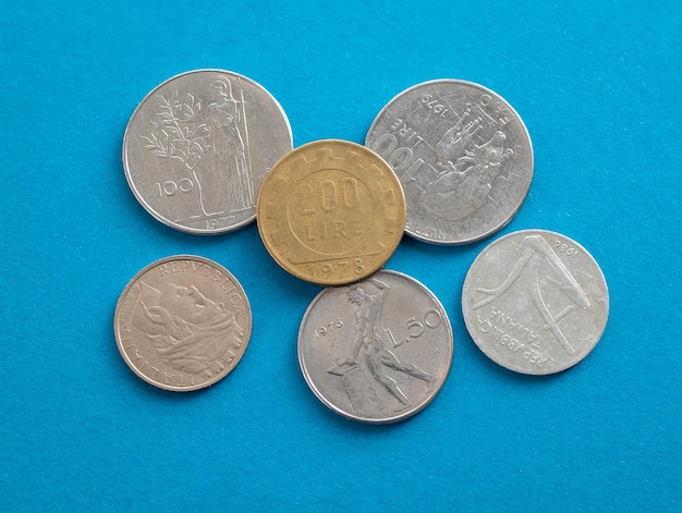 Photo les pièces italiennes avant l'euro en gros plan les anciennes pièces de la lire italienne sur le fond bleu