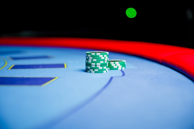 Des pièces de jeu colorées de jetons de casino se trouvent sur la table de jeu dans la pile