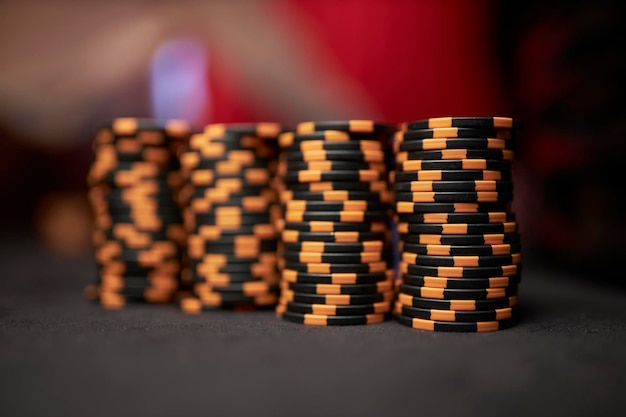 Des pièces de jeu colorées de jetons de poker se trouvent sur la table de jeu dans la pile Jetons de casino colorés