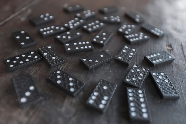 Pièces de jeu Domino éparpillées sur un vieux bureau en bois, mise au point sélective et perspective