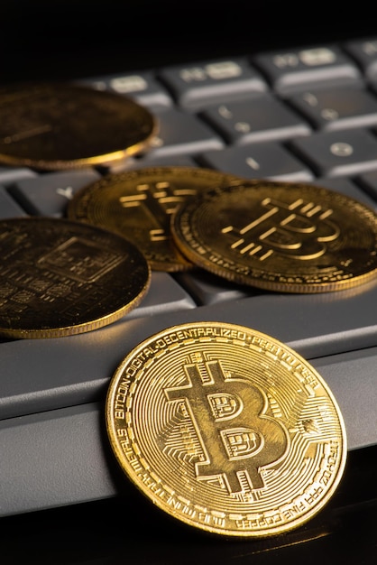 Pièces de monnaie bitcoin bitcoin avec un clavier et une souris d'ordinateur placés sur un fond sombre mise au point sélective