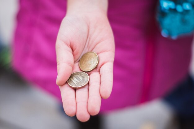 Les pièces de monnaie dans la main de l'enfant montrent le concept d'économie d'argent garder de l'argent pour la future éducation la main de l'enfant tenant des pièces en rouble