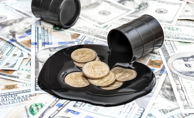 Pièces de monnaie dans le pétrole brut déversé sur fond de billets d'un dollar Concept d'entreprise