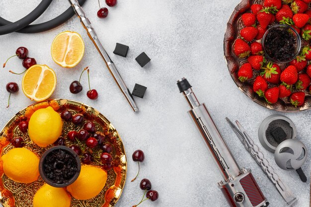 Pièces de narguilé et fraise sur une surface grise en gros plan photo