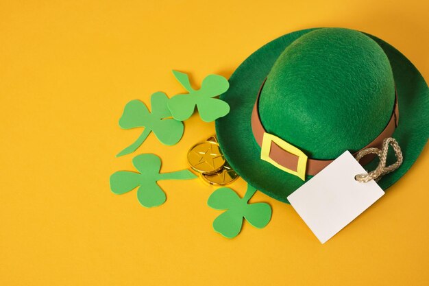 Pièces d'or chapeau de feutre de lutin vert décoratif et feuilles de trèfle foamiran sur fond jaune st patrick's day