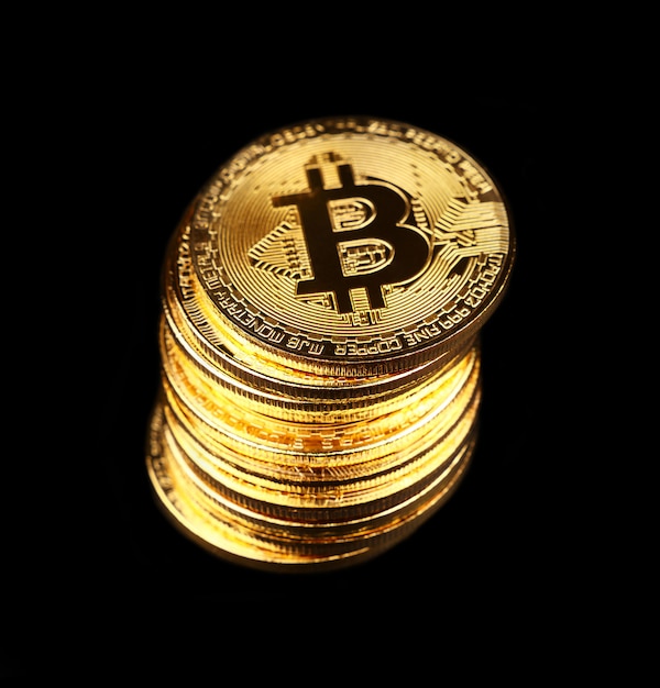 Pièces physiques Bitcoin or isolés sur fond noir