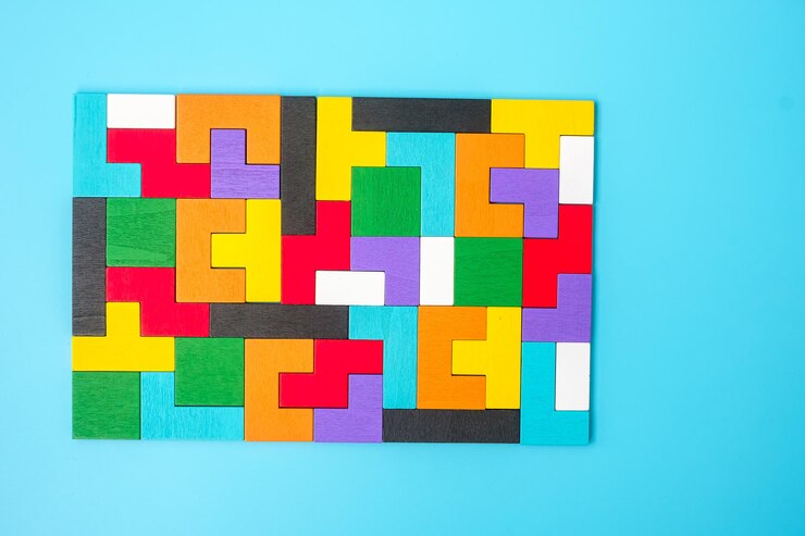 Photo pièces de puzzle en bois coloré sur fond bleu bloc de forme géométrique concepts de pensée logique solutions d'énigme stratégie rationnelle journée mondiale de la logique et éducation