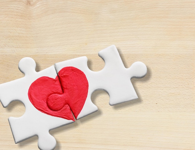 Pièces de puzzle avec coeur rouge peint sur