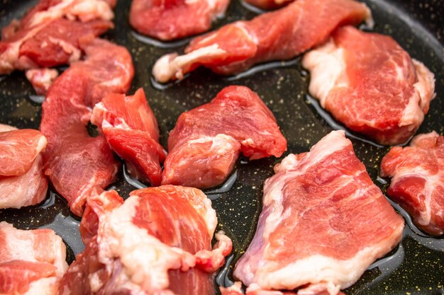 Pièces de viande crue dans une poêle à frire Pièces de viande de porc crues pour la cuisson