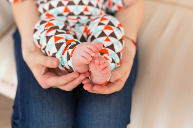 Pied de bébé dans les mains des femmes, gros plan. Jolie petite jambe d'enfant. Maternité, amour, soins, nouveau concept de vie.