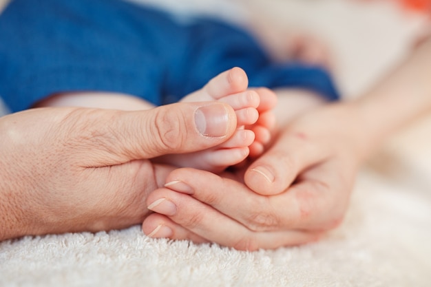 Pied de bébé dans les mains de la mère