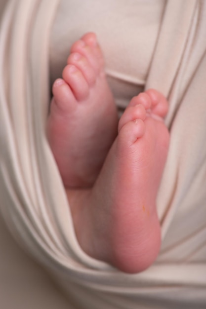 le pied d'un bébé est maintenu dans une couche