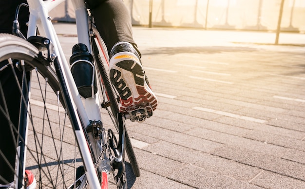 Photo pied de cycliste masculin sur une pédale de bicyclette à vélo à l'extérieur