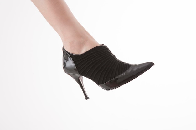 Pied de femme isolé dans les chaussures noires à talons hauts