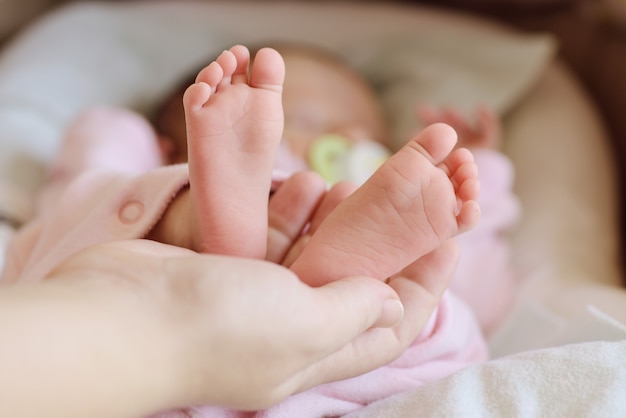 Pied de nouveau-né dans les mains de la mère