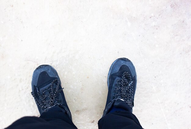 Photo pieds en baskets dans la neige vue pov homme en baskits en hiver vue pov