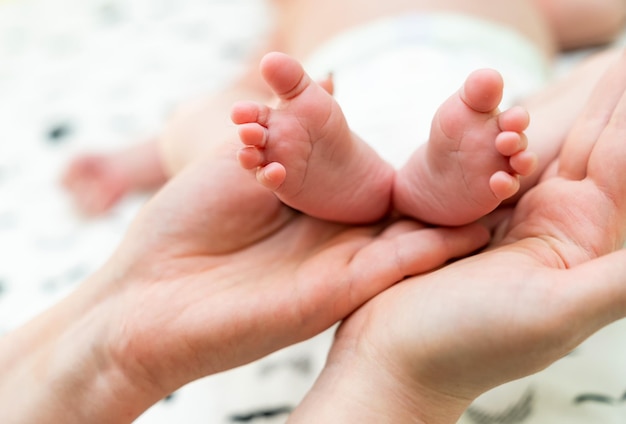 Pieds de bébé dans le bras de la mère Pieds de bébé nouveau-né