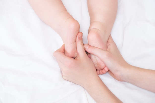 Pieds De Bébé Dans Les Mains De Maman. Les Pieds D'un Petit Nouveau-né Sur Une Forme De Main Féminine Se Bouchent. Maman Et Son Enfant.