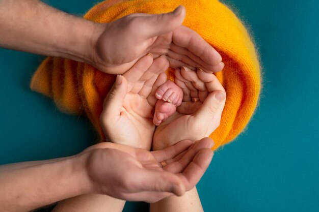 Pieds de bébé dans les mains de la mère Jambes d'un petit nouveau-né dans les bras libre Famille et enfant Happy fa