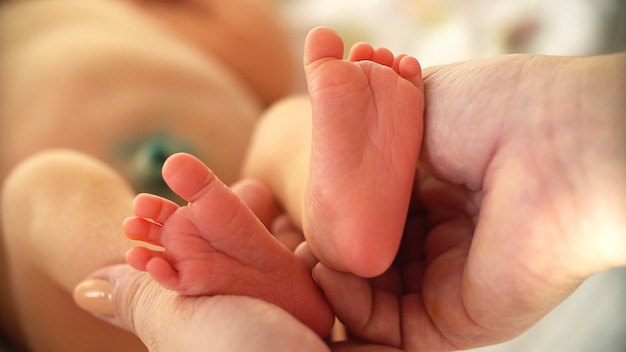 Pieds de bébé dans les mains de la mère