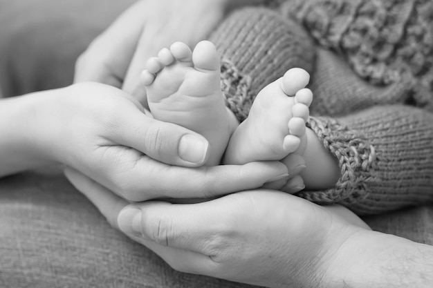 Pieds de bébé dans les mains des parents