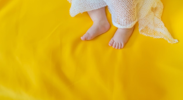 Pieds de bébé sur fond jaune.
