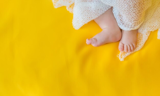 Pieds de bébé sur fond jaune.