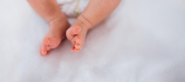 Pieds de bébé nouveau-né sur une couverture blanche Concept de maternité et de petite enfance