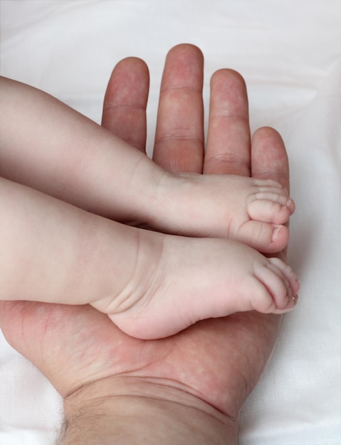 Pieds de bébé sur la paume du père