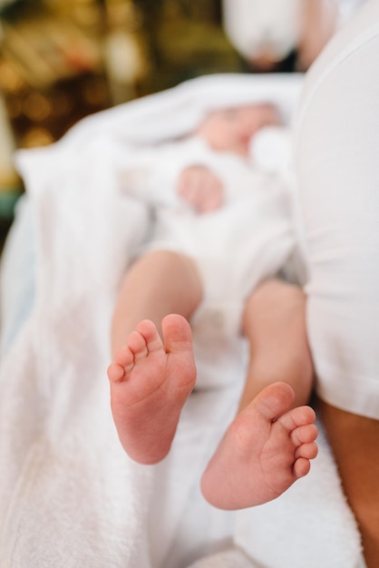 Pieds de bébé Petits pieds nus mignons d'une petite fille ou d'un garçon nouveau-né caucasien enveloppé dans une couverture blanche douce et confortable