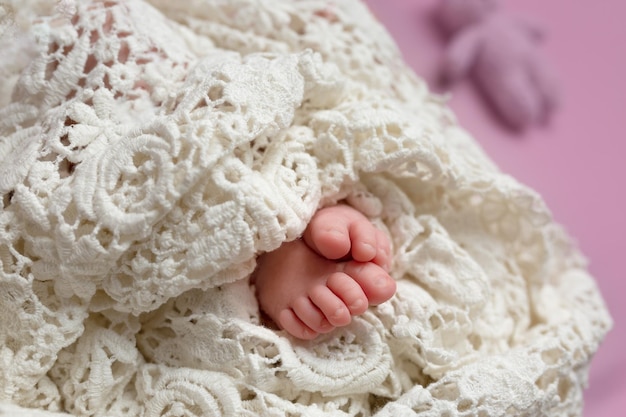 Les pieds d'un bébé sont enveloppés dans une couverture blanche.