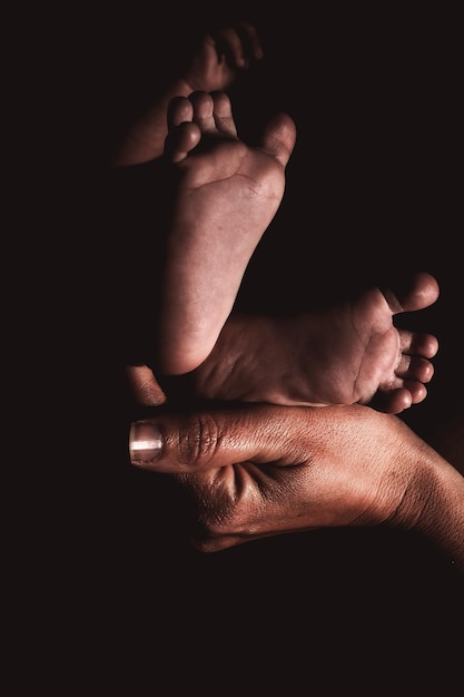 Pieds de bébé tenus par les mains de la mère photo de haute qualité