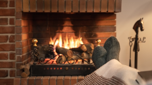 Photo pieds en chaussettes devant le feu d'une cheminée en hiver.